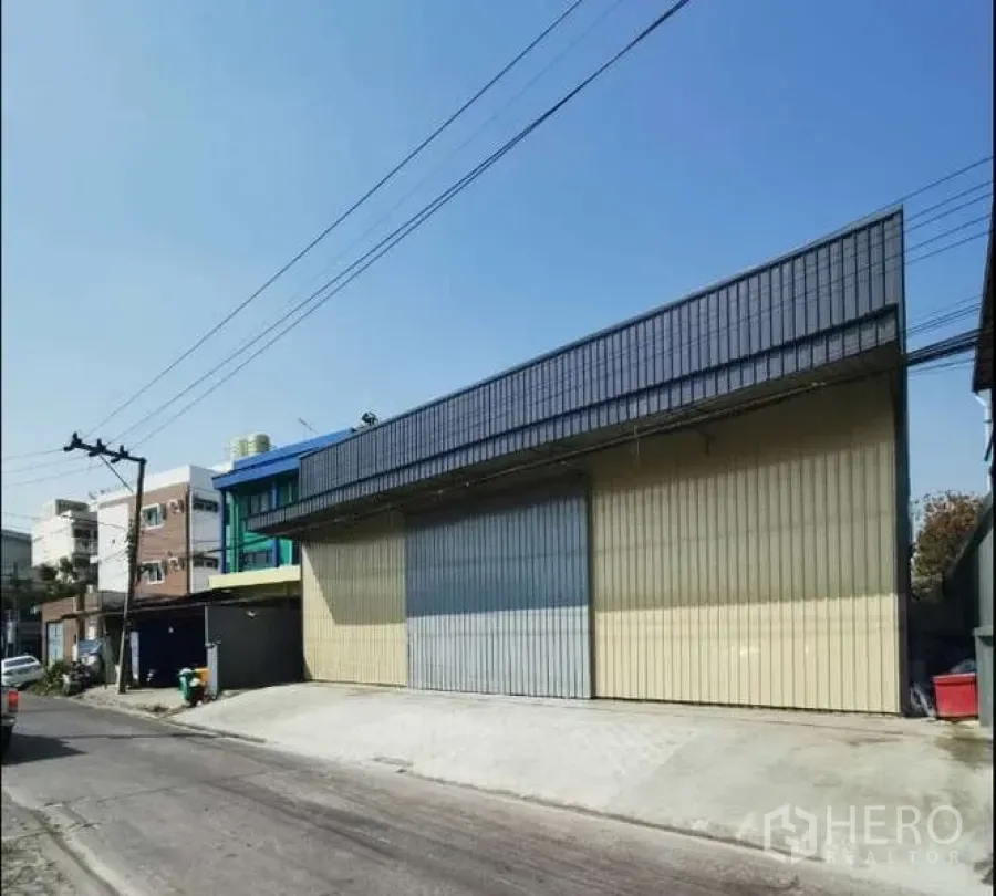 货栈 出租在Prawet, Bangkok - 临街仓库外立面，宽幅金属滑门与装卸坡道。