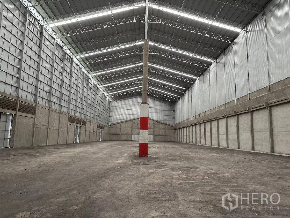 货栈 出租在Mueang Pathum Thani, Pathum Thani - 纵深视角，可见多处出入口与侧墙通风百叶，利于空气流通。