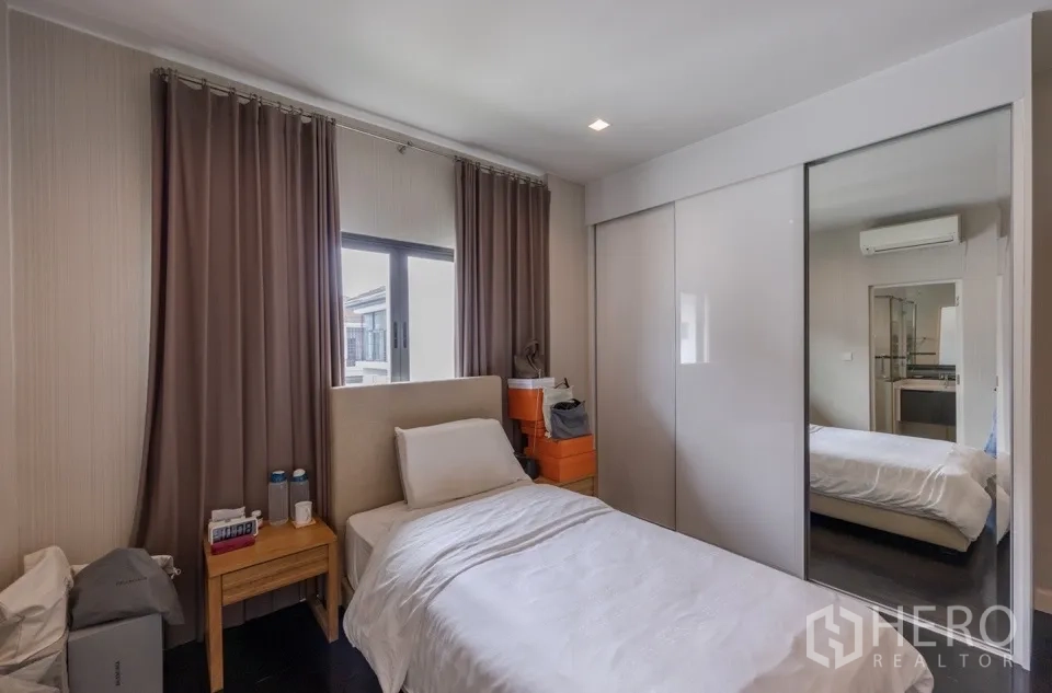 Detached House for rent or sale in Bang Kapi, Bangkok - Cozy bedroom with single bed and mirrored wardrobe doors.