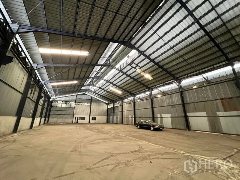 Warehouse for rent in Phra Samut Chedi, Samut Prakan - Warehouse interior with small office section and clear loading space.