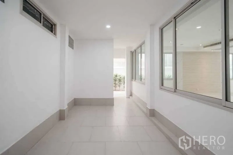 บ้าน ขายในWatthana, Bangkok - โถงทางเดินปิดล้อม มีหน้าต่างมองเข้าพื้นที่นั่งเล่น เชื่อมสวน