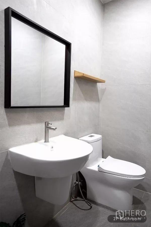 ทาวน์เฮาส์ ให้เช่าในHuai Khwang, Bangkok - ห้องน้ำชั้นสอง กระจกกรอบดำ อ่างล้างหน้า และโถสุขภัณฑ์