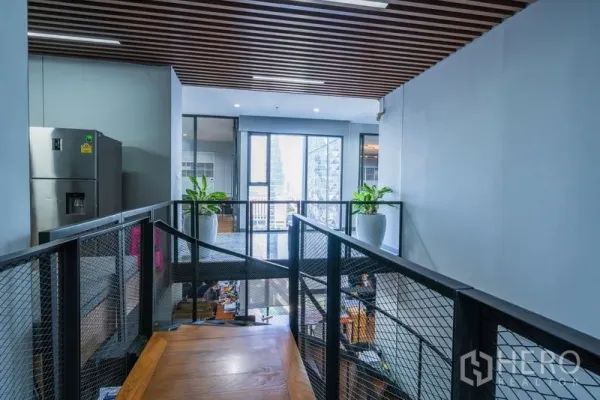Office Space for rent - Mezzanine corridor with metal railing, wood flooring, and city view windows.