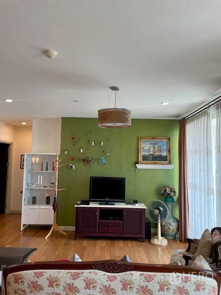 คอนโด ให้เช่าในKhlong San, Bangkok - ห้องนั่งเล่นผนังสีเขียว มีชั้นวางทีวีและประตูกระจกบานเลื่อน