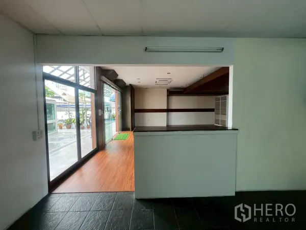 พื้นที่ขายปลีก ให้เช่า - มุมมองจากเคาน์เตอร์ด้านหลังไปยังหน้าร้านกระจกและทางเดินมีหลังคา