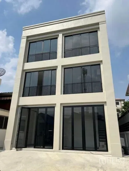 带办公室的家 出租或出售在Bang Na, Bangkok - 三层现代家居式办公楼外立面，黑框落地窗