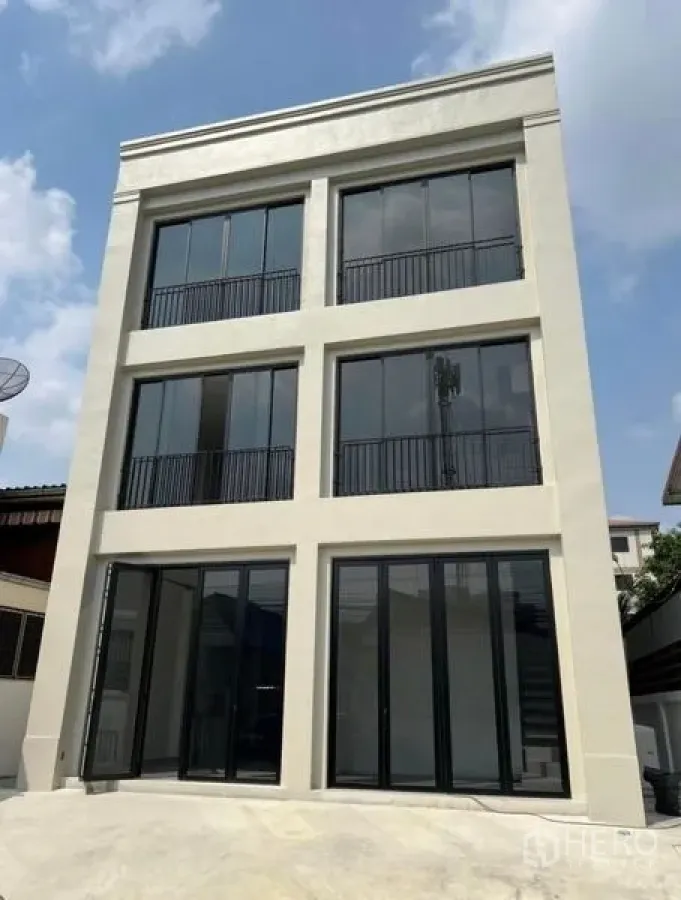 带办公室的家 出租或出售在Bang Na, Bangkok - 三层现代家居式办公楼外立面，黑框落地窗