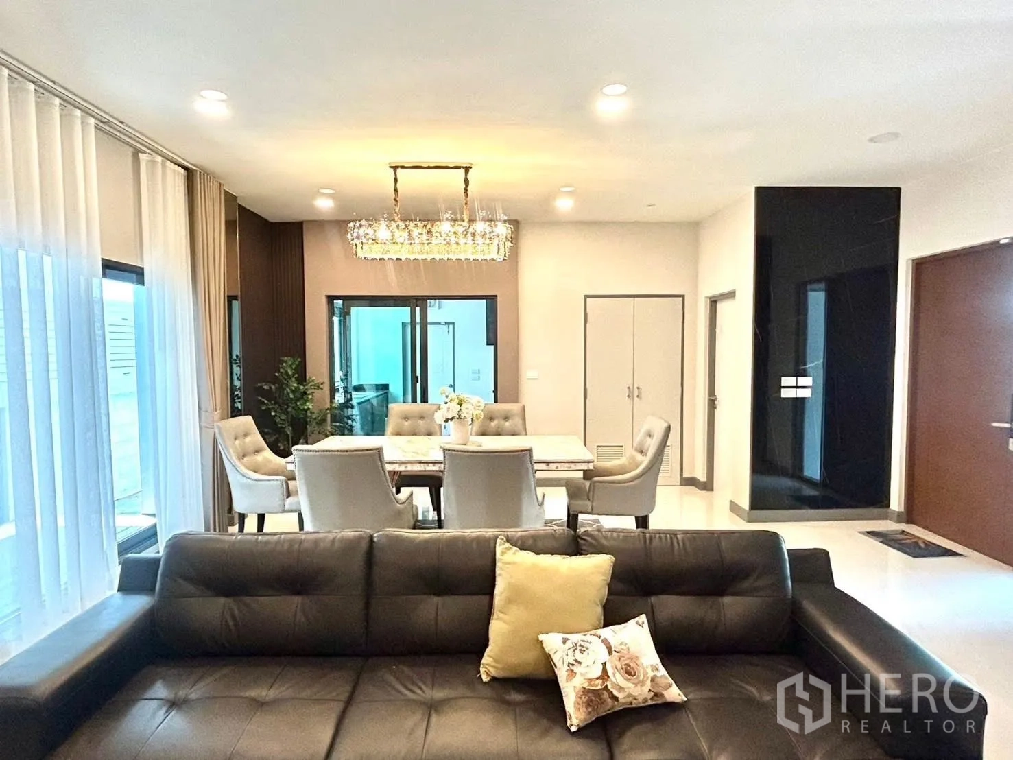 独栋房屋 for rent in Bang Phli, Samut Prakan - 从皮沙发望向餐区与推拉玻璃门的视角。