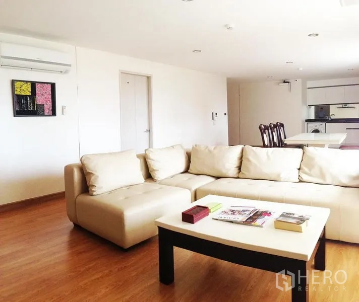 คอนโด ให้เช่าในKhlong Toei, Bangkok - ห้องนั่งเล่นโปร่งสว่าง โซฟาเข้ามุมสีครีม โต๊ะกลาง และพื้นลามิเนตลายไม้