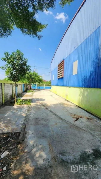 货栈 出租在Nong Chok, Bangkok - 沿仓库侧边延伸的混凝土通道，通向前方大门。