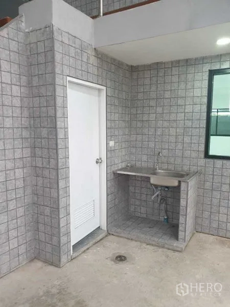 Warehouse for rent in Prawet, Bangkok - Ground-floor utility sink and service area beside the interior office door.
