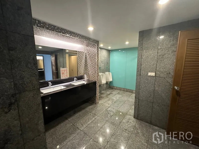 Office Space for rent - Modern shared restroom with granite tiles, double sinks and urinals.
