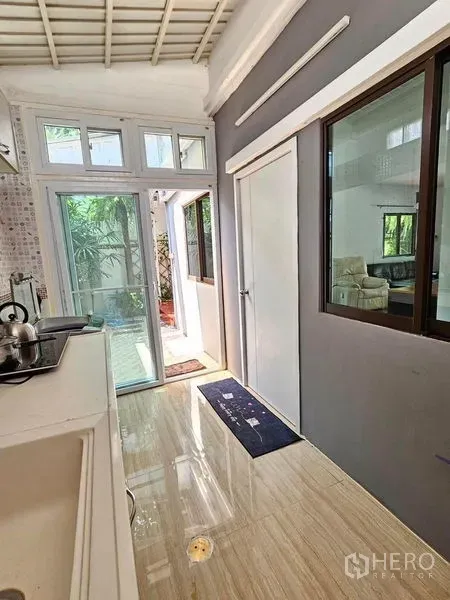 ทาวน์เฮาส์ ให้เช่า - โถงอเนกประสงค์สว่างพร้อมประตูกระจกสไลด์เปิดสู่สวนด้านข้าง