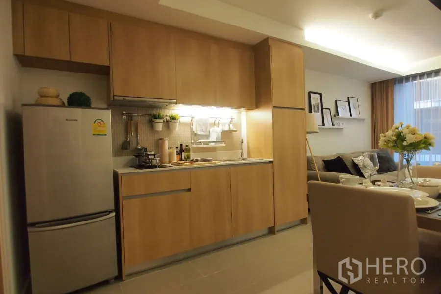 คอนโด ให้เช่าในPathum Wan, Bangkok - ครัวบิลท์อินโทนไม้พร้อมตู้เย็นและมุมทานอาหาร เชื่อมต่อพื้นที่นั่งเล่น คอนโดใกล้ BTS เพลินจิต