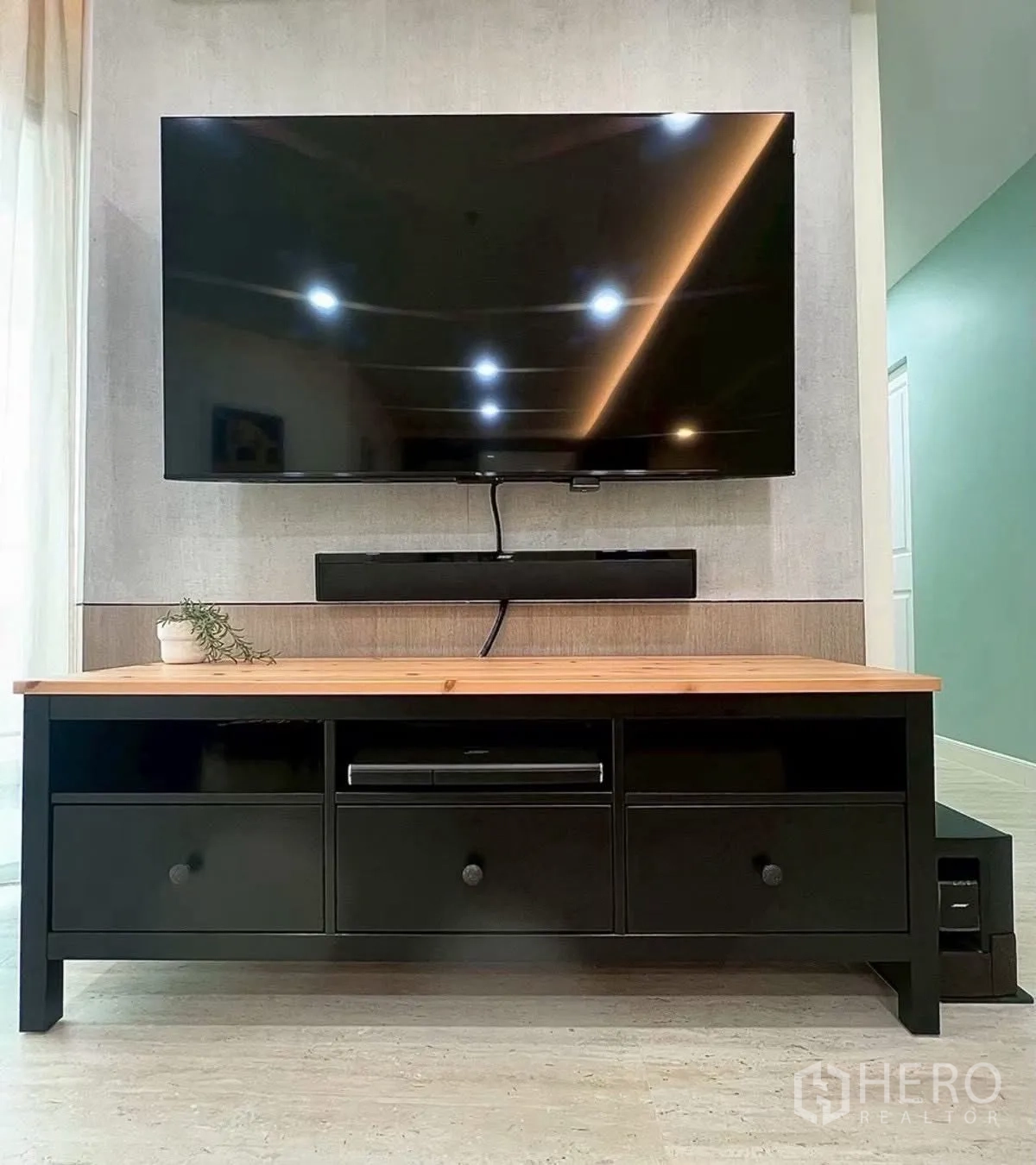 Condominium for rent in Huai Khwang, Bangkok - Wall-mounted flat-screen TV with media console in living area.