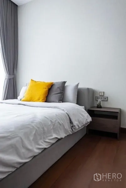 คอนโด ให้เช่า - ห้องนอนที่สอง ชุดเครื่องนอนสีเทาอ่อนและหมอนแต้มสีเหลือง