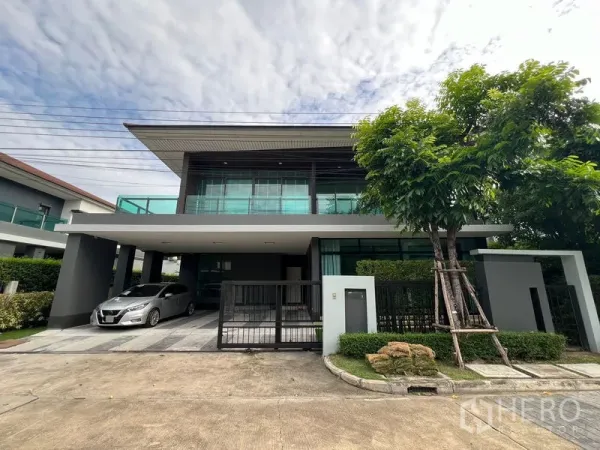 Detached House for rent in Bang Kapi, Bangkok - Front exterior of modern house with gated driveway and carport.