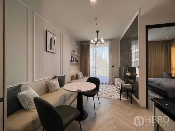 Condominium for rent - Bright living and dining area with built-in bench seating, round table, TV wall and large window with sheer curtains