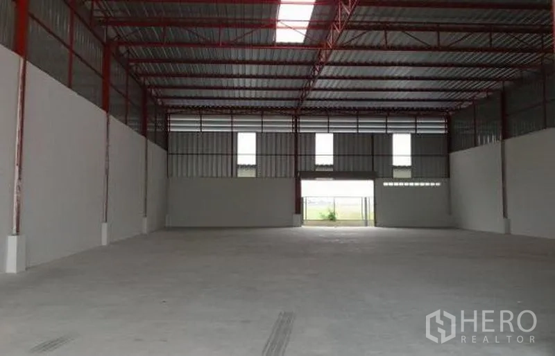 工厂 出租在Pathum Thani - 空旷的工厂车间，屋顶采光带与通风窗贯通两端。