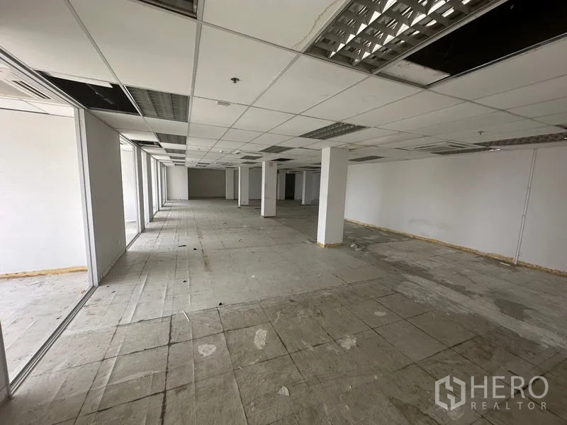 Office Space for rent in Khlong Toei, Bangkok - Deep floor plate office with structural columns and glass partitions along one side.