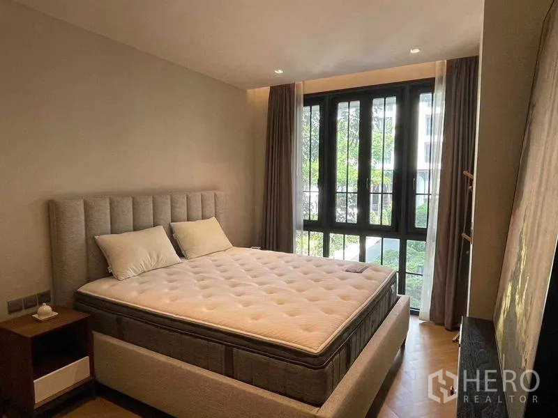 Condominium for rent - Bright bedroom with upholstered bed, large windows and garden outlook.