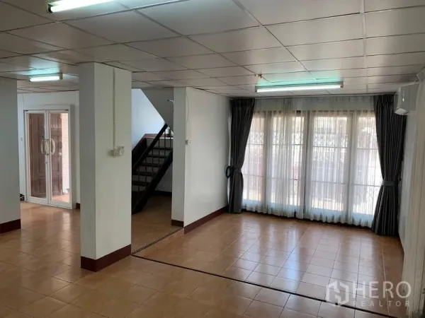 办公空间 出租在Chatuchak, Bangkok - 开放式办公区，瓷砖地面，玻璃入户门、楼梯与落地窗帘。