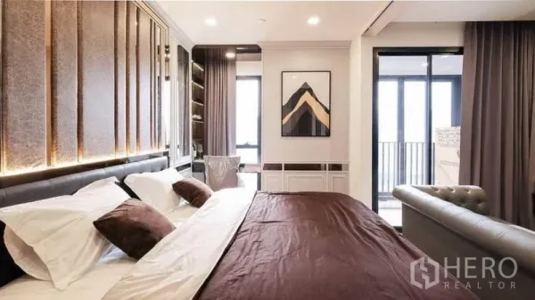 คอนโด ให้เช่าในBang Rak, Bangkok - เตียงคิงไซซ์พร้อมไฟซ่อน ภาพงานศิลป์ และหน้าต่างสูงจรดเพดานเปิดสู่ระเบียง