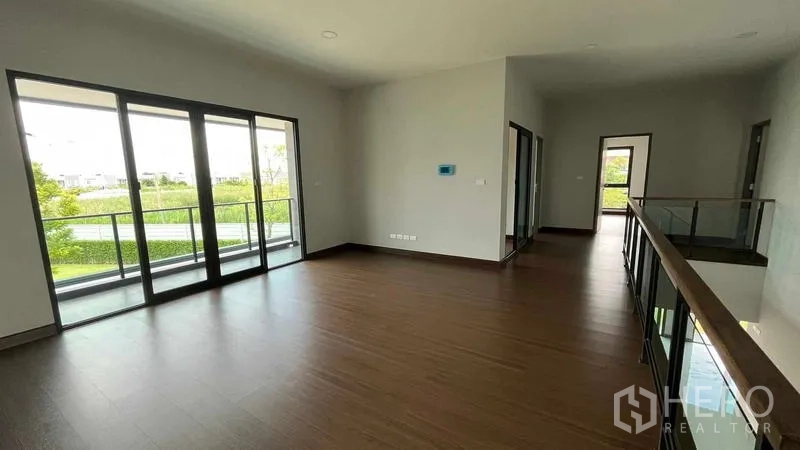 Detached House for sale in Bang Phli, Samut Prakan - Upstairs family lounge opening to a glass-railed balcony with green views.