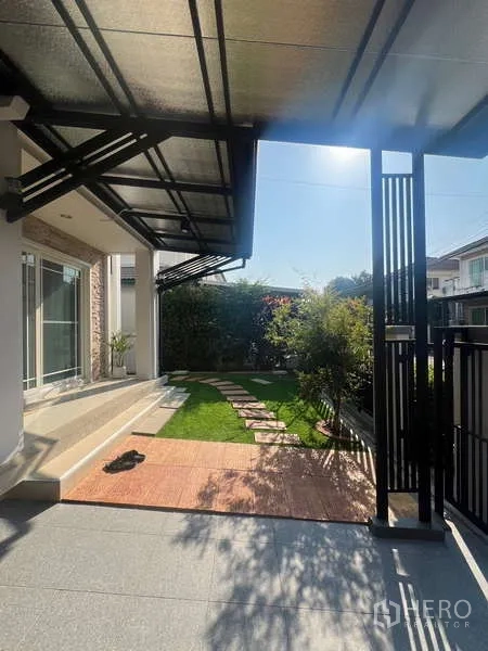 บ้าน ให้เช่าในBang Kapi, Bangkok - ชานหน้าบ้านมีหลังคา เปิดสู่สนามหญ้าและทางเดินแผ่นทาง