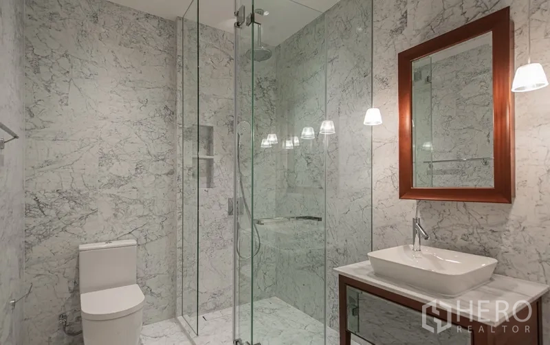 公寓 出售在Watthana, Bangkok - 大理石卫浴，玻璃淋浴间、马桶与现代洗手台。