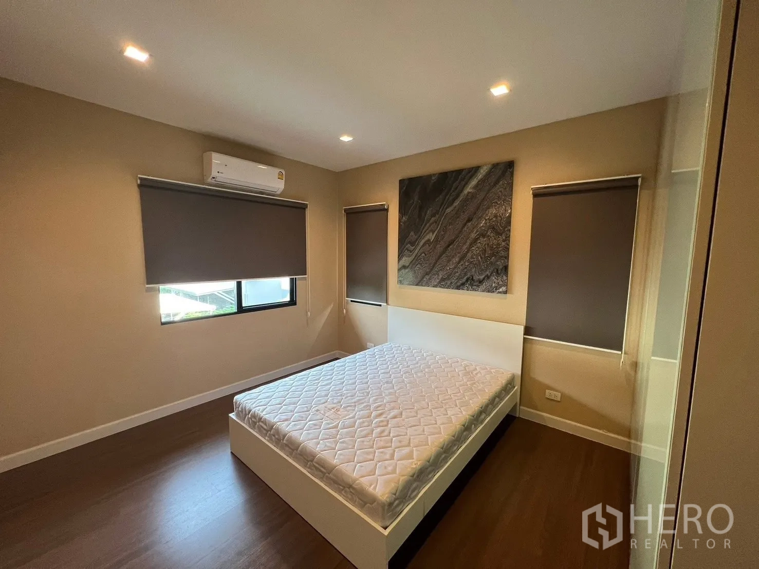 Detached House for rent in Bang Phli, Samut Prakan - Cozy secondary bedroom with air conditioning, blackout roller blinds, wood flooring, and wall art.