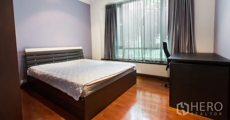 Condominium for rent in Sathon, Bangkok - Second bedroom with double bed, study desk and big window with curtains.