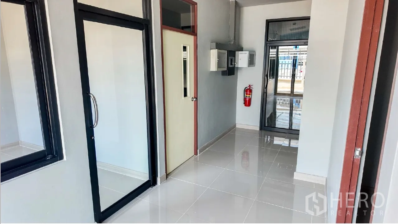 โกดัง for rent in Mueang Chon Buri, Chon Buri - โถงทางเข้า มีประตูกระจก ตู้ไฟ และถังดับเพลิงติดผนัง