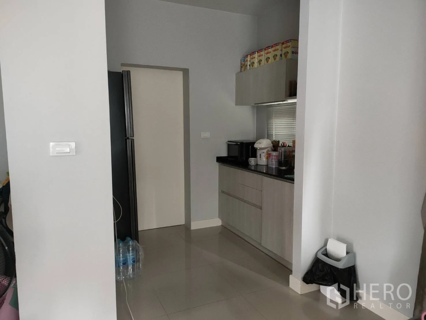 บ้าน ให้เช่าหรือขายในLam Luk Ka, Pathum Thani - แพนทรีขนาดกะทัดรัด ตู้แขวนและท็อปสีดำ ถัดจากช่องวางตู้เย็น