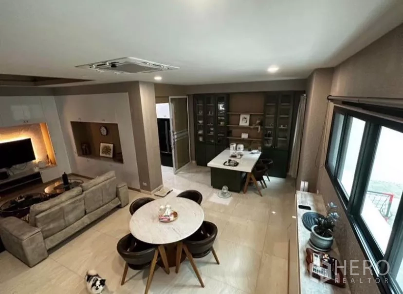 ทาวน์เฮาส์ ให้เช่าในYan Nawa, Bangkok - โถงนั่งเล่นและทานอาหารแบบเปิดโล่ง มีโซฟา โต๊ะกลม และตู้บิลท์อิน ข้างหน้าต่างบานใหญ่