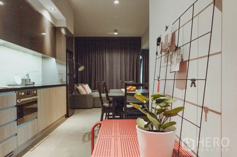 Condominium for rent in Watthana, Bangkok - Entry corridor with decorative plant and wire wall grid leading to the living area.