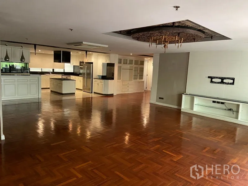 คอนโด ขายในKhlong San, Bangkok - พื้นที่นั่งเล่นรับประทานอาหารโอเพ่นแพลน พื้นไม้ปาร์เกต์เงา พร้อมครัวสีขาวขนาดใหญ่