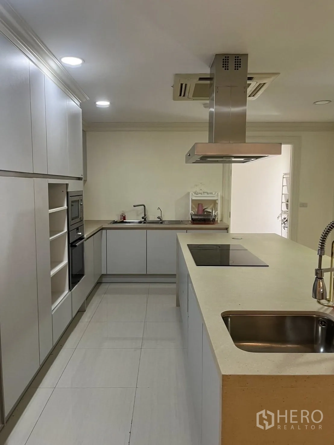 Home Office for rent in Watthana, Bangkok - Modern kitchen with an island, induction hob, and ample cabinets.