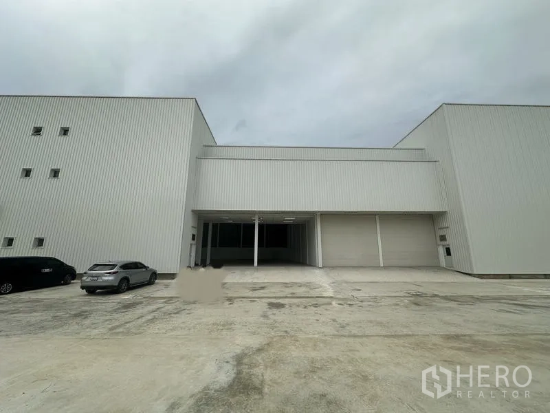 โรงงาน ให้เช่าในPathum Thani - ด้านหน้าอาคารโหลดดิ้งเบย์ มีหลังคากันสาดและประตูม้วนหลายจุด