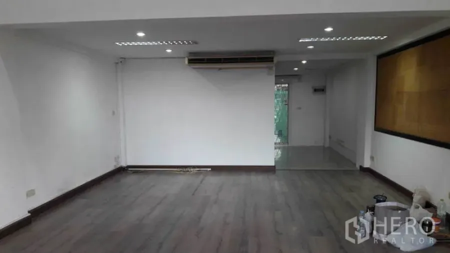 Office Space for rent in Bueng Kum, Bangkok - Ground-floor office with dark wood flooring, recessed lights and AC unit.