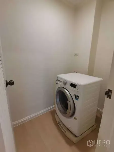 อพาร์ทเมนท์ ให้เช่า - มุมซักผ้าแบบกะทัดรัดพร้อมเครื่องซักผ้าฝาหน้าและพื้นไม้โทนอ่อน