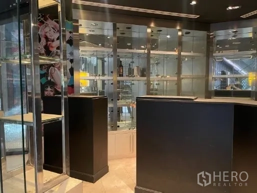 零售空间 出租在Watthana, Bangkok - 内置玻璃货架与黑色柜台，零售空间内配嵌入式照明。