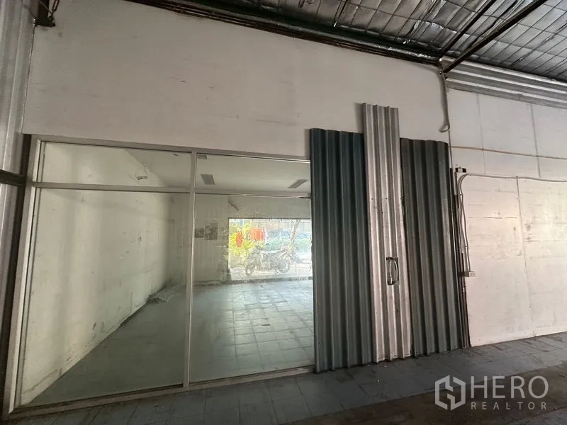 Warehouse for rent in Saphan Sung, Bangkok - Internal glass-partitioned office connected to the warehouse with metal sliding doors.