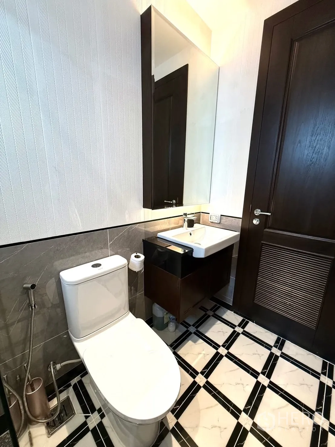 Detached House for rent or sale in Bang Phli, Samut Prakan - Modern bathroom with toilet, wall mirror, vanity and patterned marble-look floor tiles.