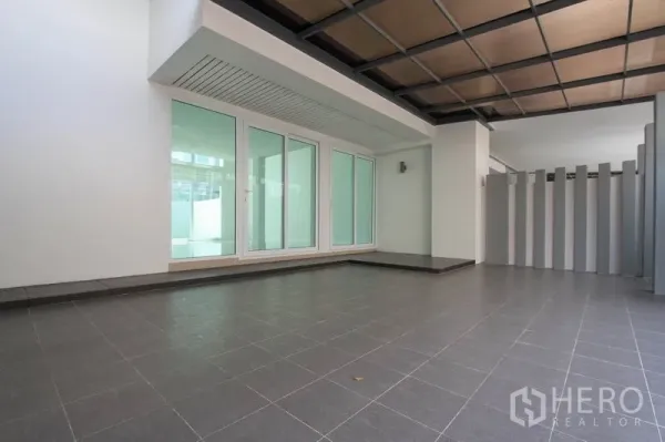 ทาวน์เฮาส์ ขายในWang Thonglang, Bangkok - พื้นที่จอดรถกว้างโปร่ง มีหน้าต่างฝ้ากระจกและพื้นกระเบื้องสีเทาด้านหน้าบ้าน