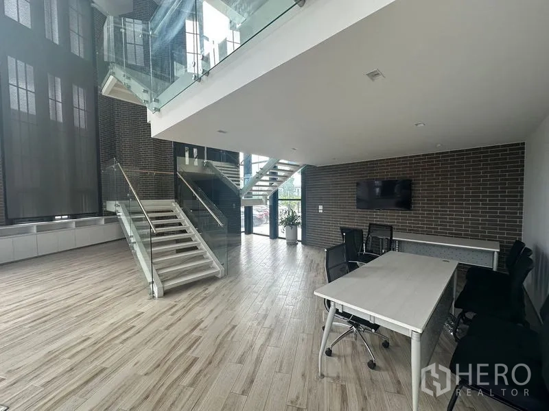 พื้นที่ขายปลีก ให้เช่าในBang Phli, Samut Prakan - โถงรับรองพร้อมบันไดกระจก เพดานสูง และโต๊ะประชุม