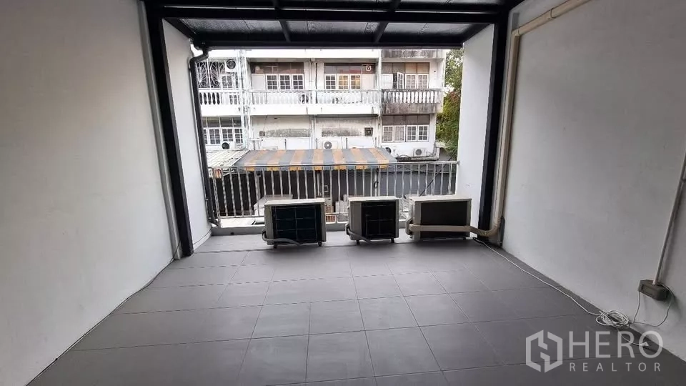 ทาวน์เฮาส์ ให้เช่าในHuai Khwang, Bangkok - ระเบียงมีหลังคา วางคอมเพรสเซอร์แอร์ มองเห็นทาวน์เฮ้าส์ฝั่งตรงข้าม