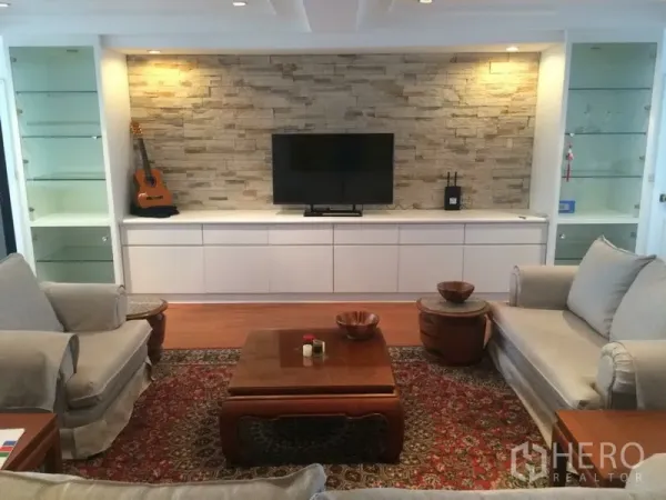 คอนโด ให้เช่าในKhlong Toei, Bangkok - ผนังจุดเด่นลายหินพร้อมทีวี ชั้นโชว์กระจก และโซฟาคู่รอบพรม