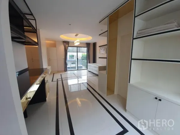Home Office for rent in Bueng Kum, Bangkok - Upper floor workspace with glossy tile floors, balcony doors, and custom cabinetry.