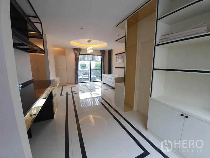 Home Office for rent in Bueng Kum, Bangkok - Upper floor workspace with glossy tile floors, balcony doors, and custom cabinetry.